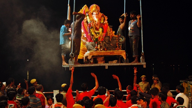 Devotees lift an idol of Lord Ganesha before immersing it in the Hussain Sagar Lake during Ganesh Chaturthi in Hyderabad. (Image: Newindianexpress.com)